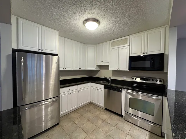 a kitchen with stainless steel appliances granite countertop a refrigerator stove a sink and dishwasher