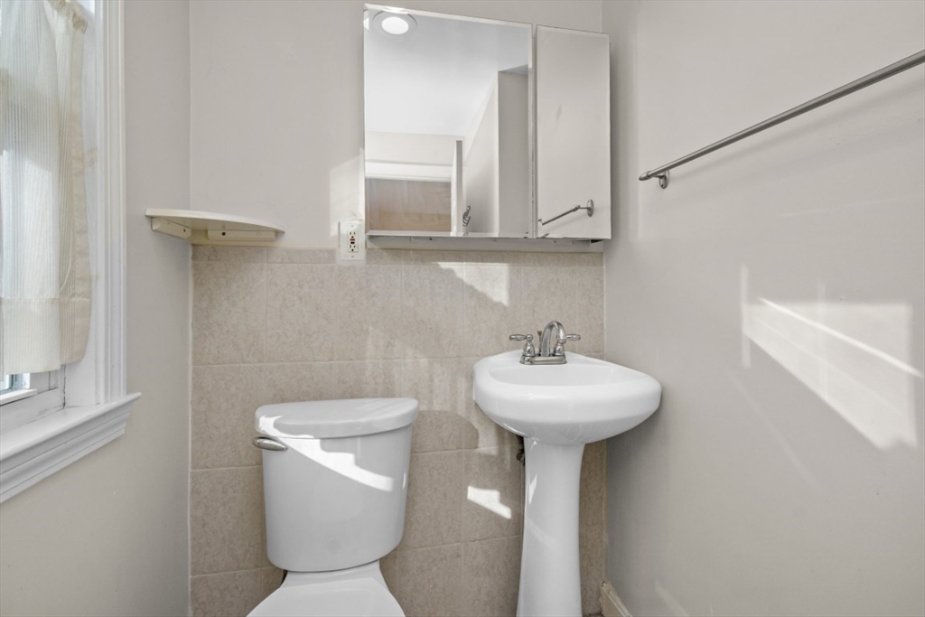 41 Whittemore Road, Unit 1 Newton, MA 02458 - Photo 14 of 18 a bathroom with a sink a mirror and a toilet