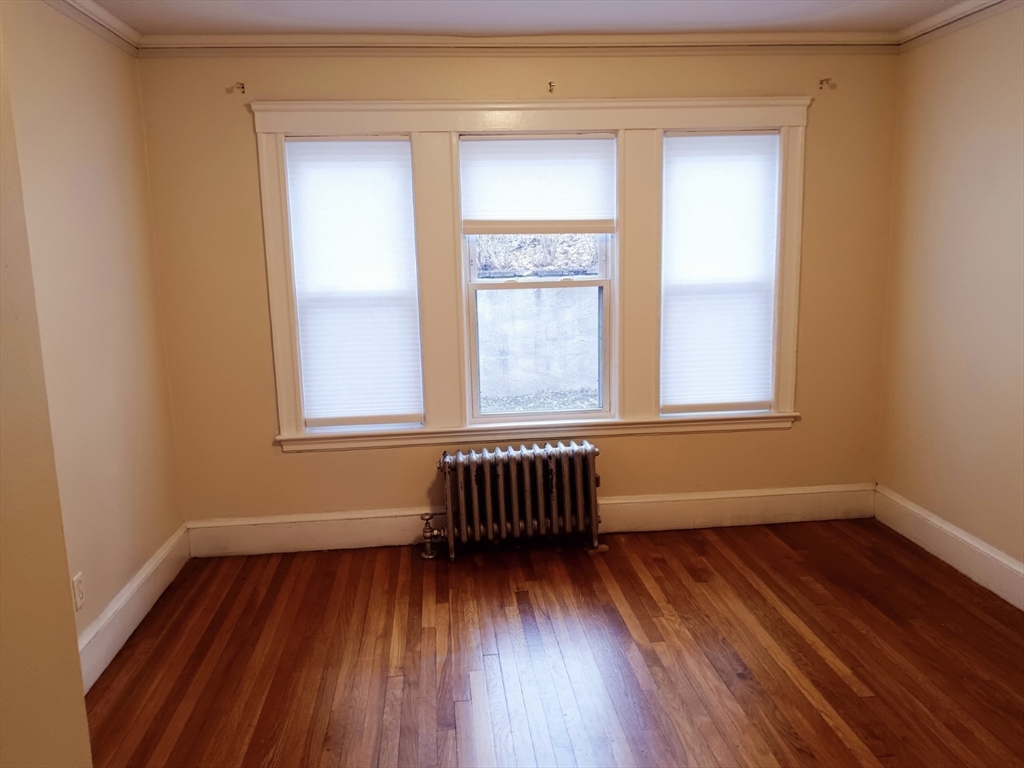 41 Whittemore Road, Unit 1 Newton, MA 02458 - Photo 16 of 18 a view of an empty room with wooden floor and a window