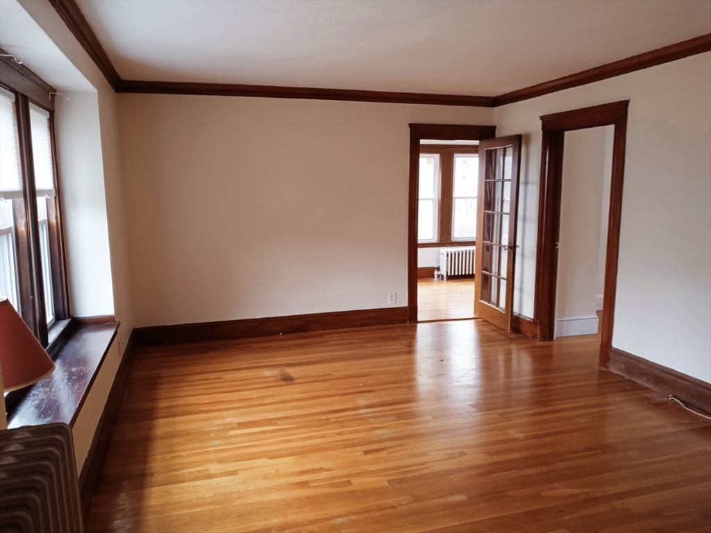 41 Whittemore Road, Unit 1 Newton, MA 02458 - Photo 17 of 18 a view of an empty room with wooden floor and a window