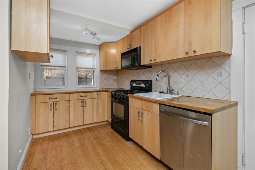 41 Whittemore Road, Unit 1 Newton, MA 02458 - Photo 7 of 18 a kitchen with stainless steel appliances granite countertop a sink and cabinets with wooden floor