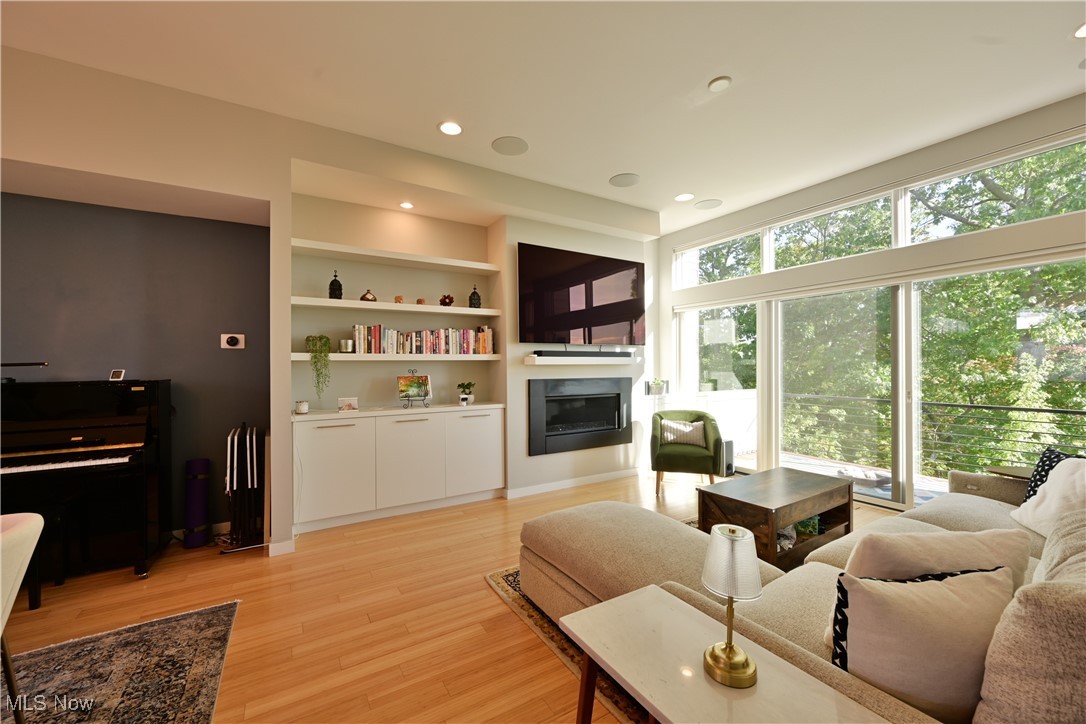18875 Riversouth Fairview Park, Unit 30 Cleveland, OH 44126 - Photo 5 of 39 Living area with a glass covered fireplace, recessed lighting, light wood-style floors, and built in features
