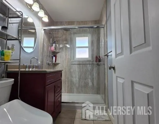 a bathroom with a sink a toilet a mirror and shower