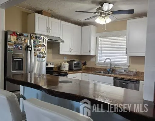 a kitchen with kitchen island granite countertop a sink appliances cabinets and counter space