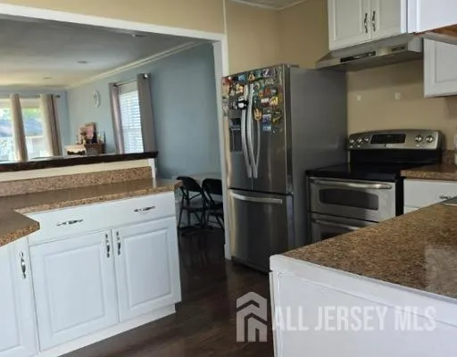a kitchen with a refrigerator and a stove top oven
