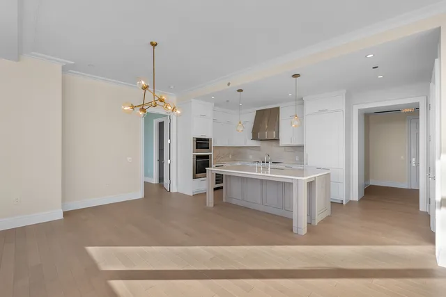 a view of kitchen with sink refrigerator and cabinets