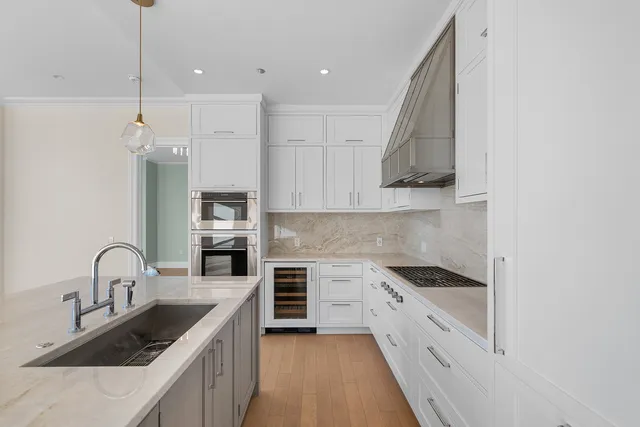 a kitchen with stainless steel appliances granite countertop a sink stove and cabinets