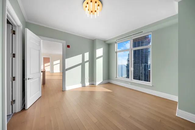 a view of an empty room with glass door and a window