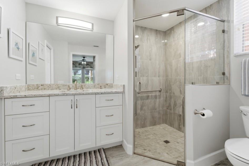 10024 Heather Lane, Unit 1001 Naples, FL 34119 - Photo 11 of 23 a bathroom with a shower sink vanity and mirror