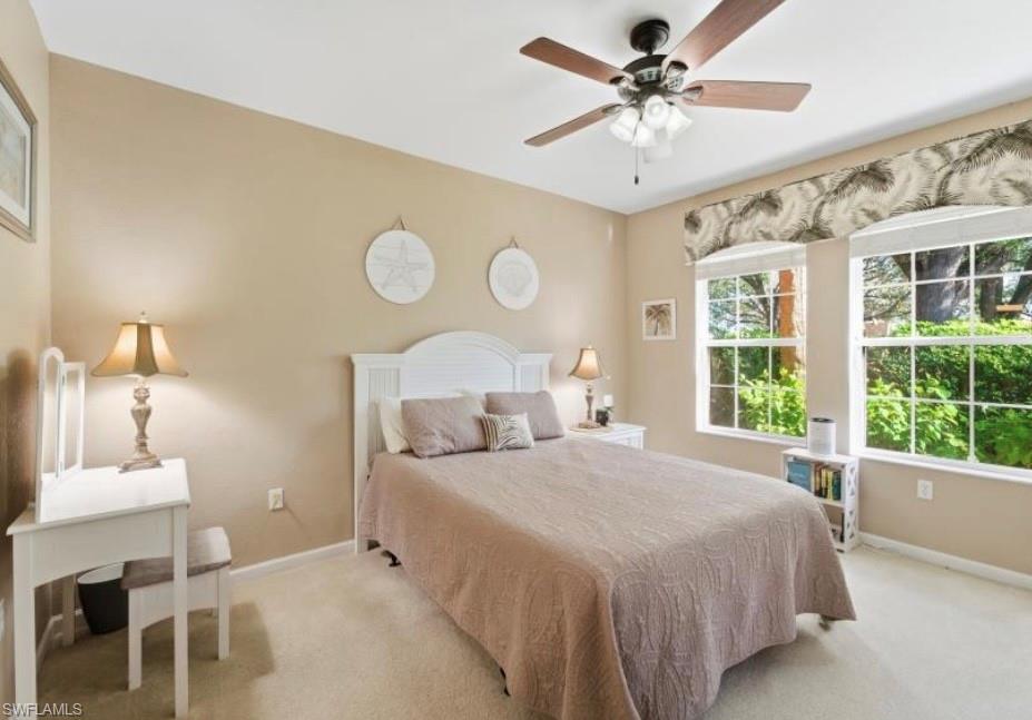 10024 Heather Lane, Unit 1001 Naples, FL 34119 - Photo 13 of 23 a bedroom with a bed and a table with a large window