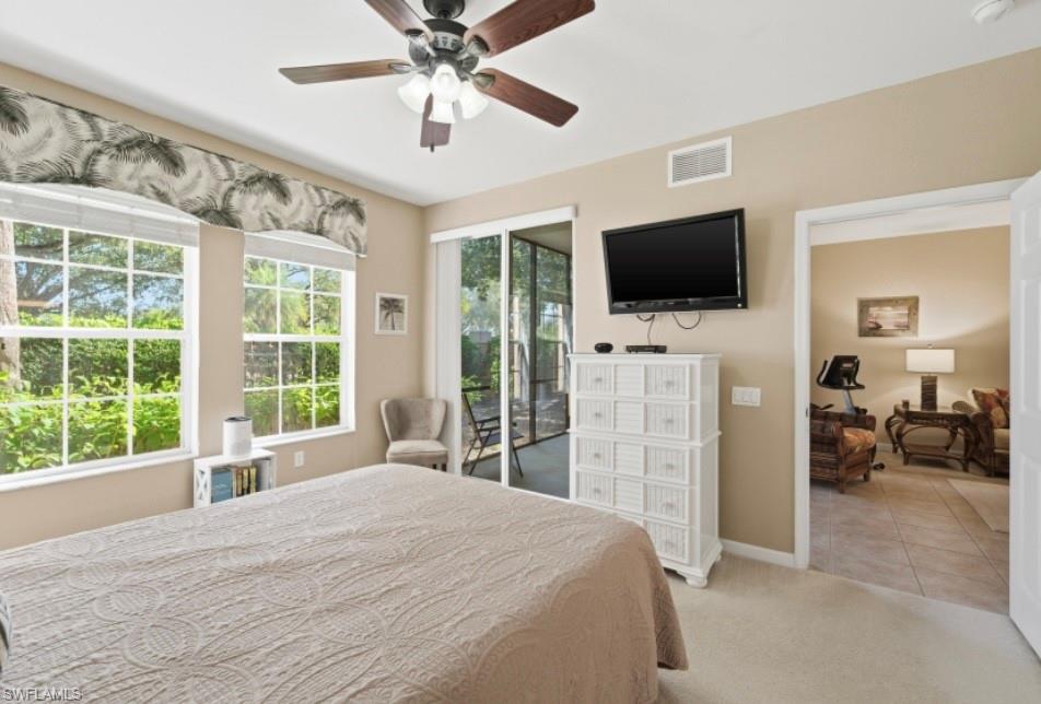 10024 Heather Lane, Unit 1001 Naples, FL 34119 - Photo 16 of 23 a bedroom with a bed and a flat screen tv