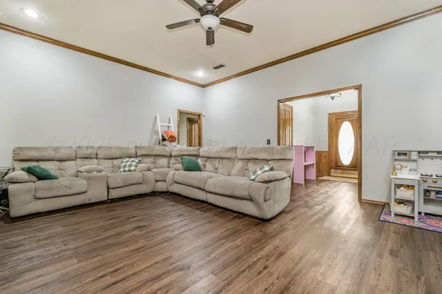 a living room with furniture and a wooden floor