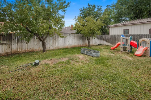 a view of a backyard with a tree and a slide