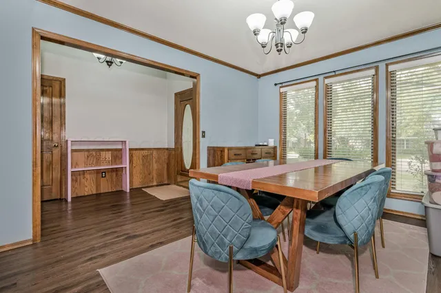 a dining room with furniture a chandelier and wooden floor