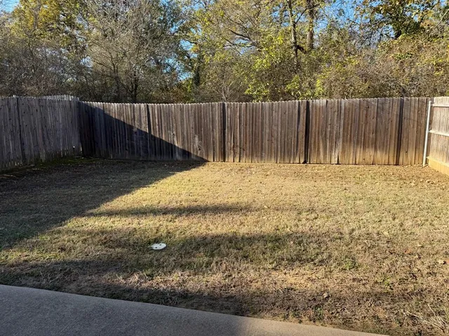 a backyard of a house with wooden fence