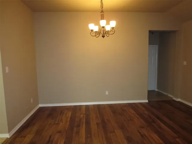 a view of a room with wooden floor and chandelier