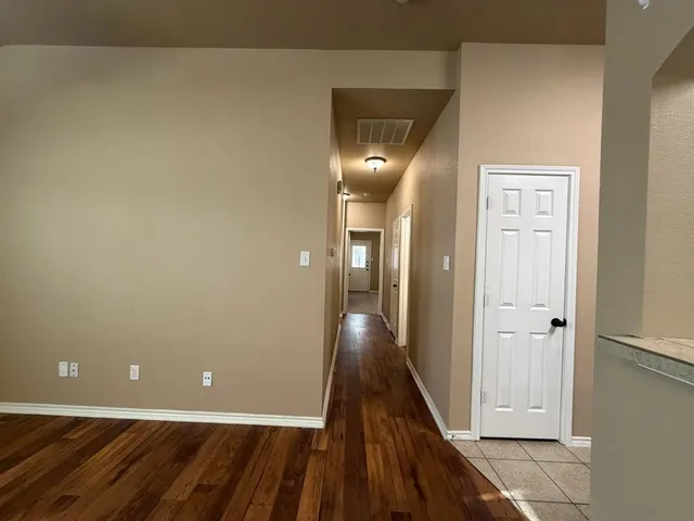 a view of a hallway with wooden floor