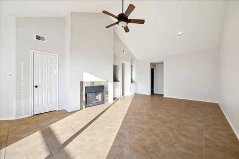 a view of a livingroom with a ceiling fan a fireplace and a ceiling fan