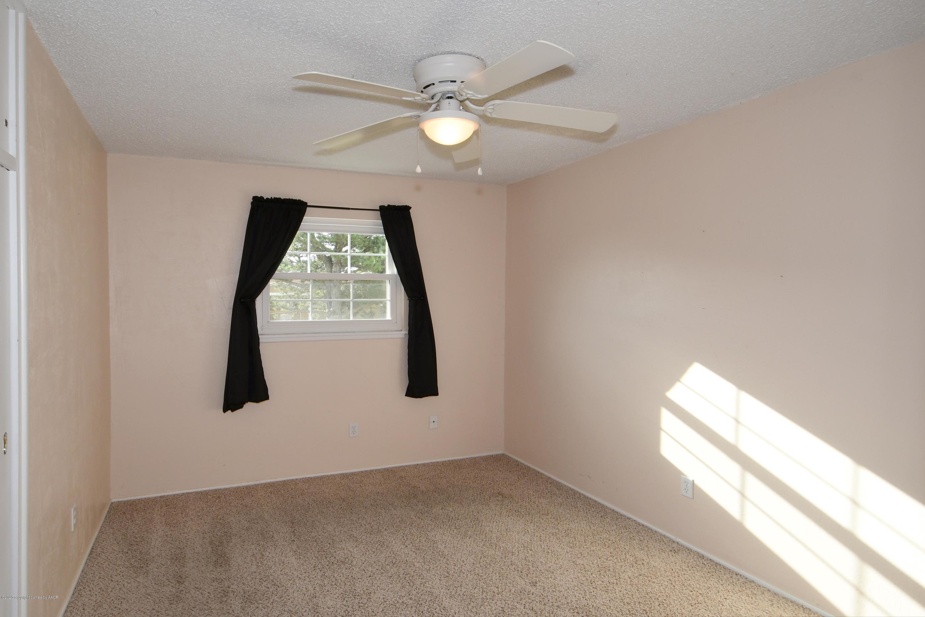 5204 South Travis Street Amarillo, TX 79110 - Photo 13 of 25 en empty room with windows and ceiling fan