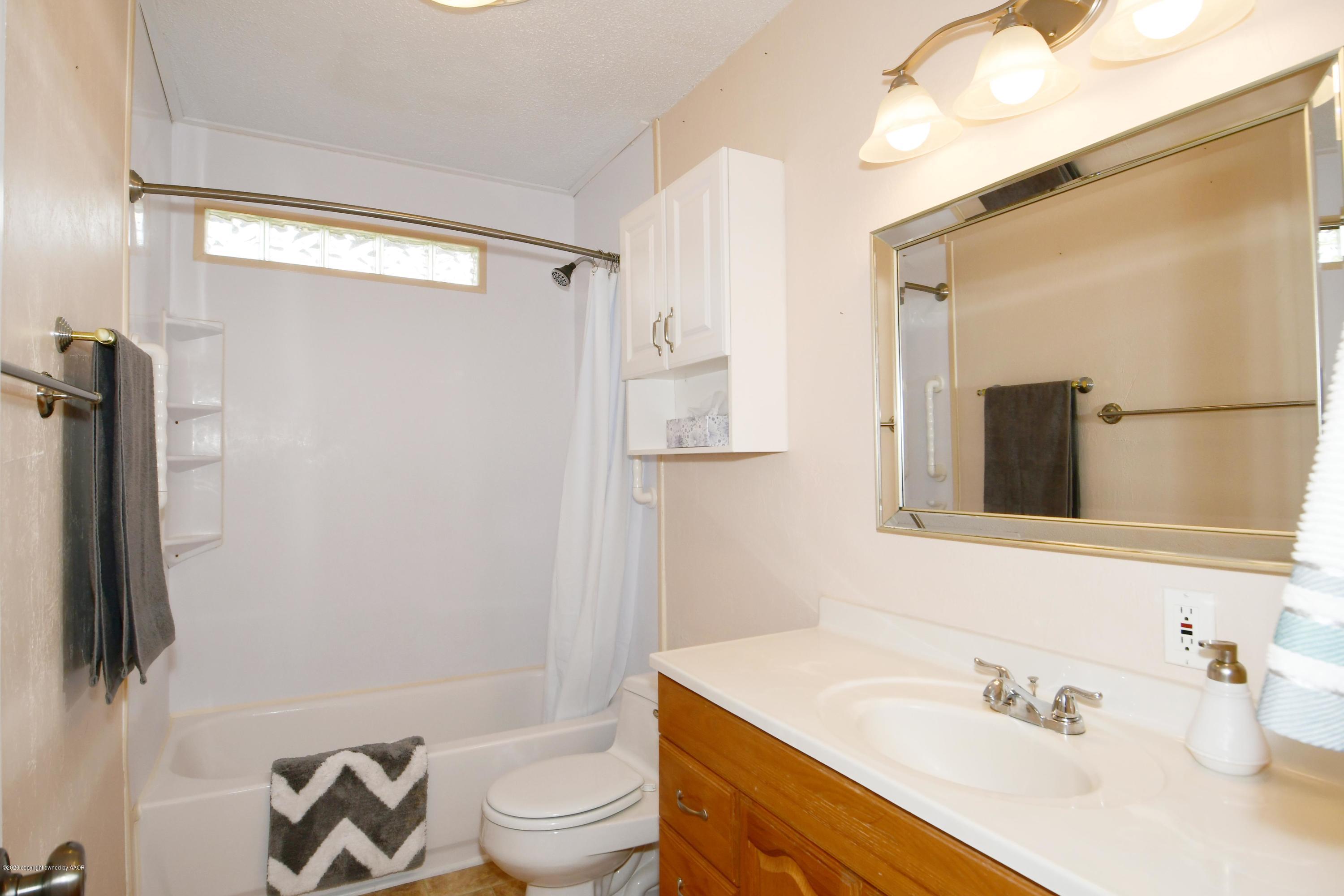 5204 South Travis Street Amarillo, TX 79110 - Photo 15 of 25 a bathroom with a sink toilet and shower