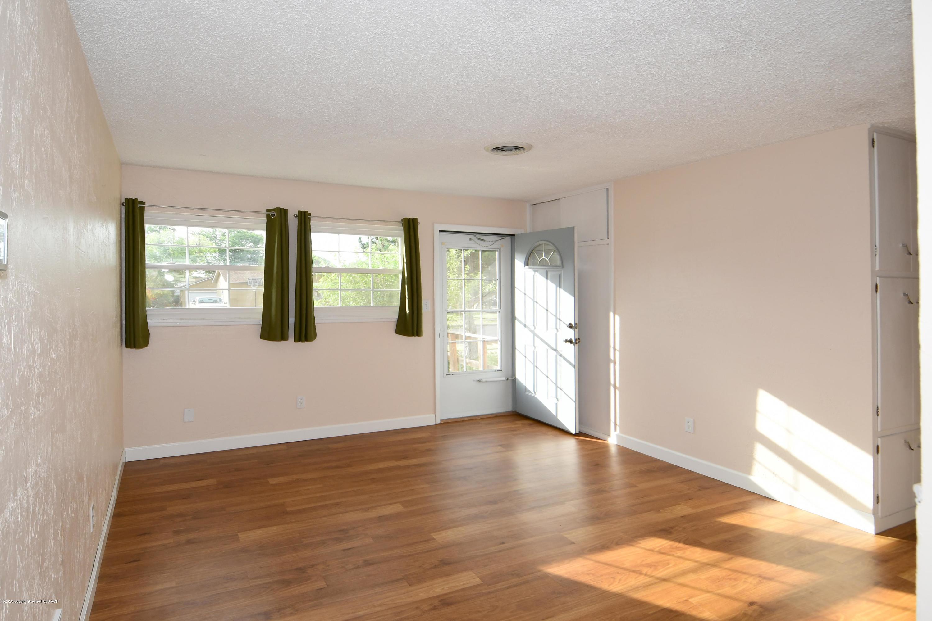 5204 South Travis Street Amarillo, TX 79110 - Photo 3 of 25 a view of an empty room with window and wooden floor