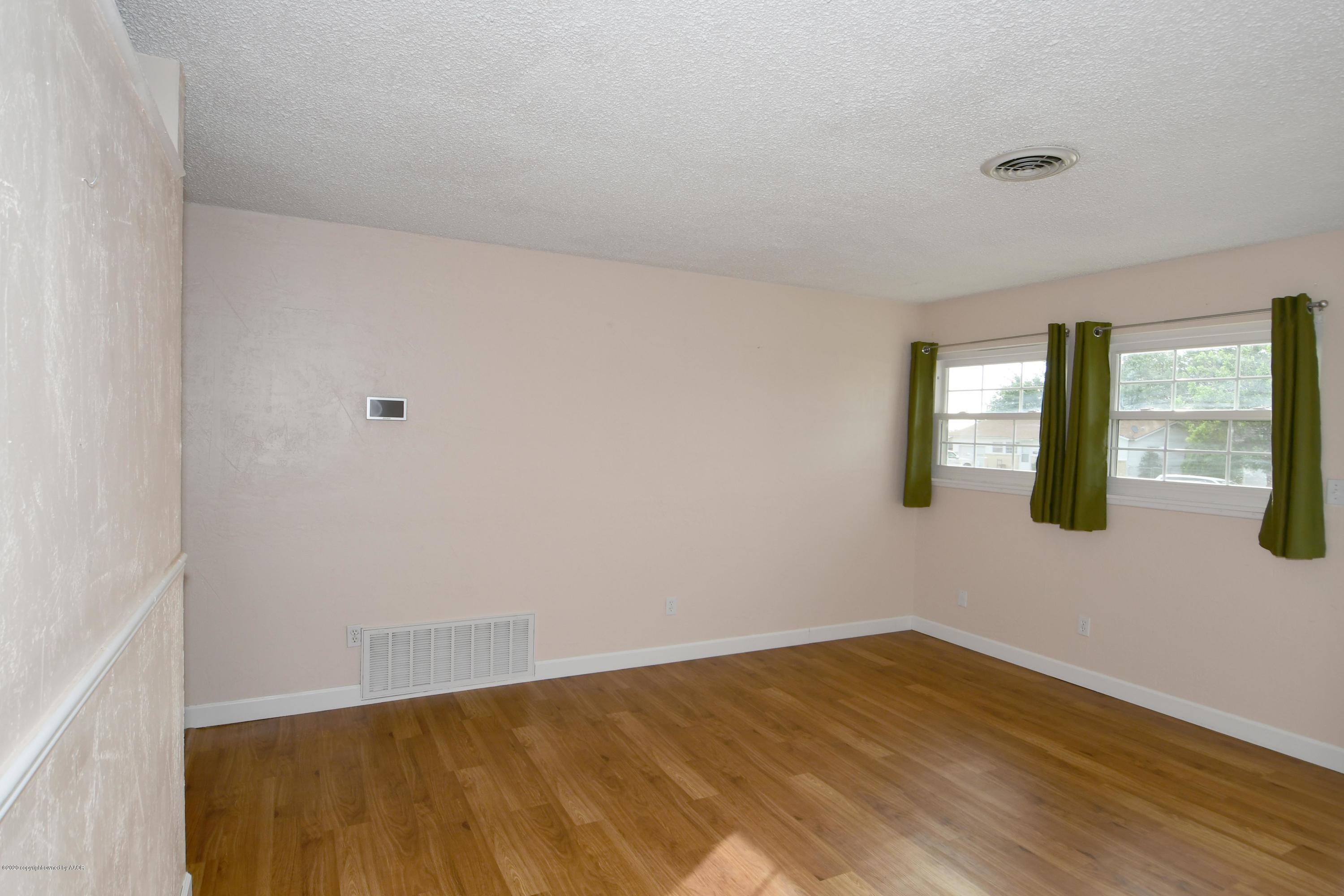 5204 South Travis Street Amarillo, TX 79110 - Photo 4 of 25 a view of an empty room with wooden floor and windows