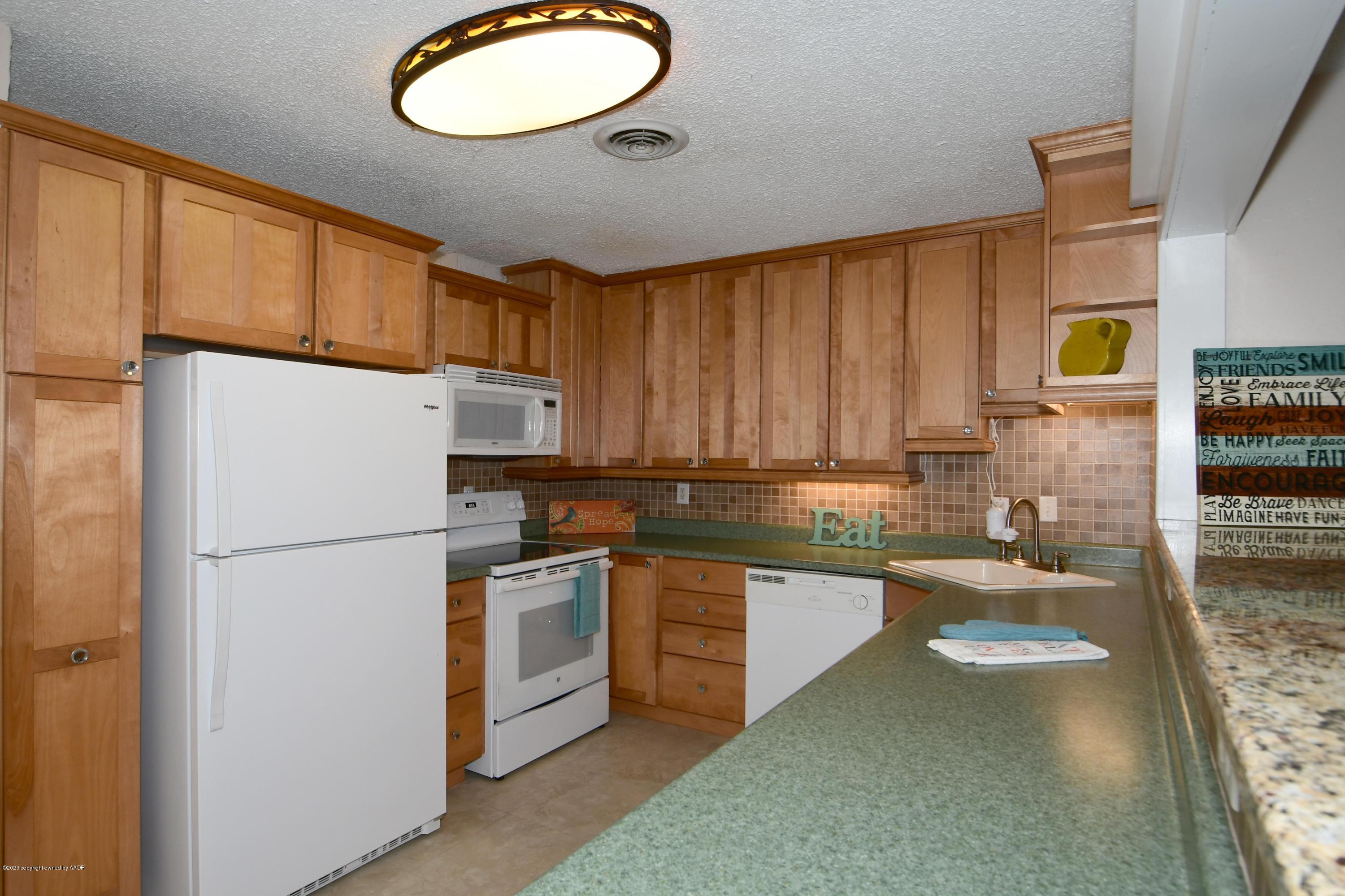 5204 South Travis Street Amarillo, TX 79110 - Photo 5 of 25 a kitchen with a sink refrigerator and cabinets
