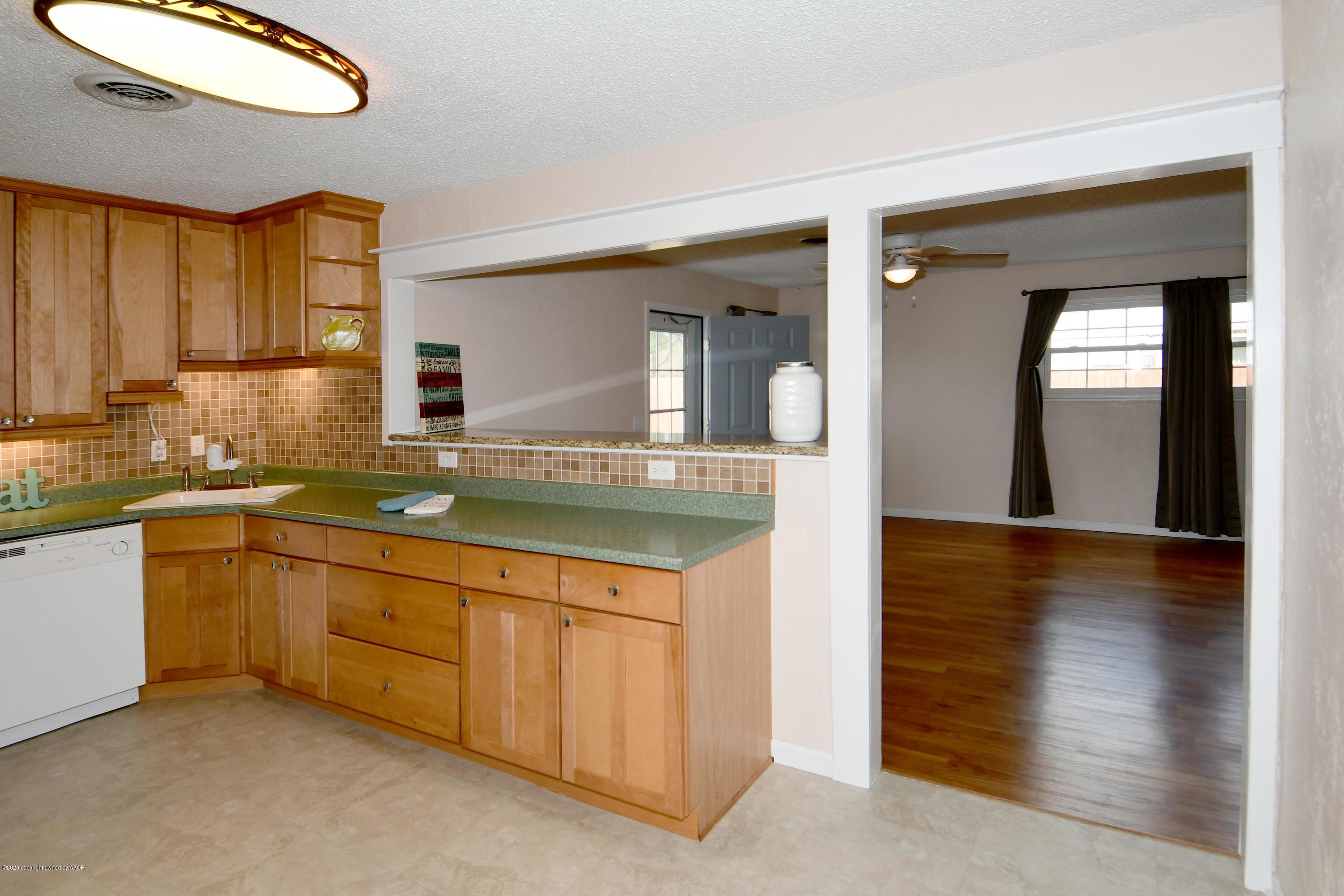 5204 South Travis Street Amarillo, TX 79110 - Photo 8 of 25 a kitchen with granite countertop a sink and cabinets