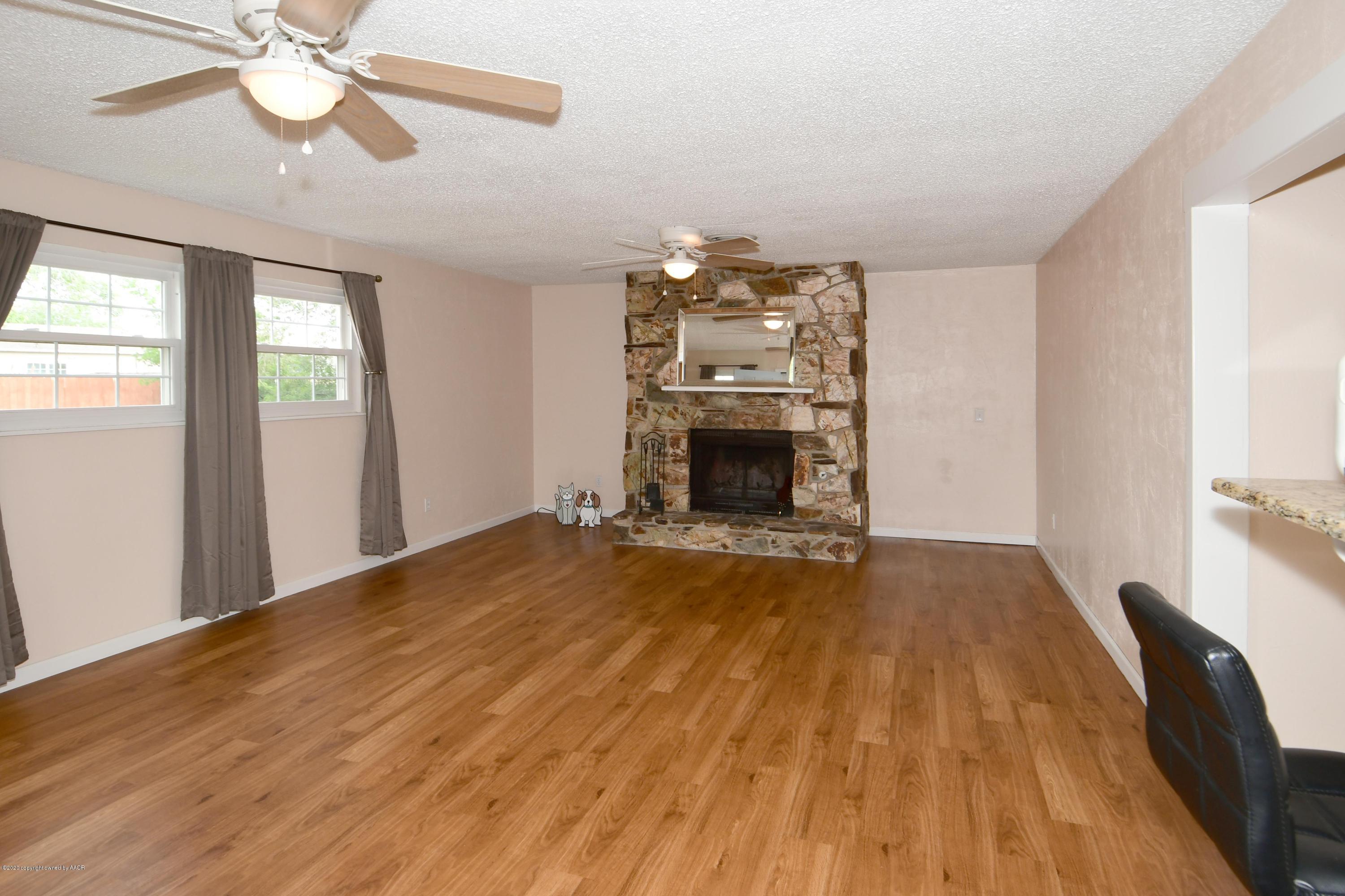5204 South Travis Street Amarillo, TX 79110 - Photo 10 of 25 a view of empty room with wooden floor and fan