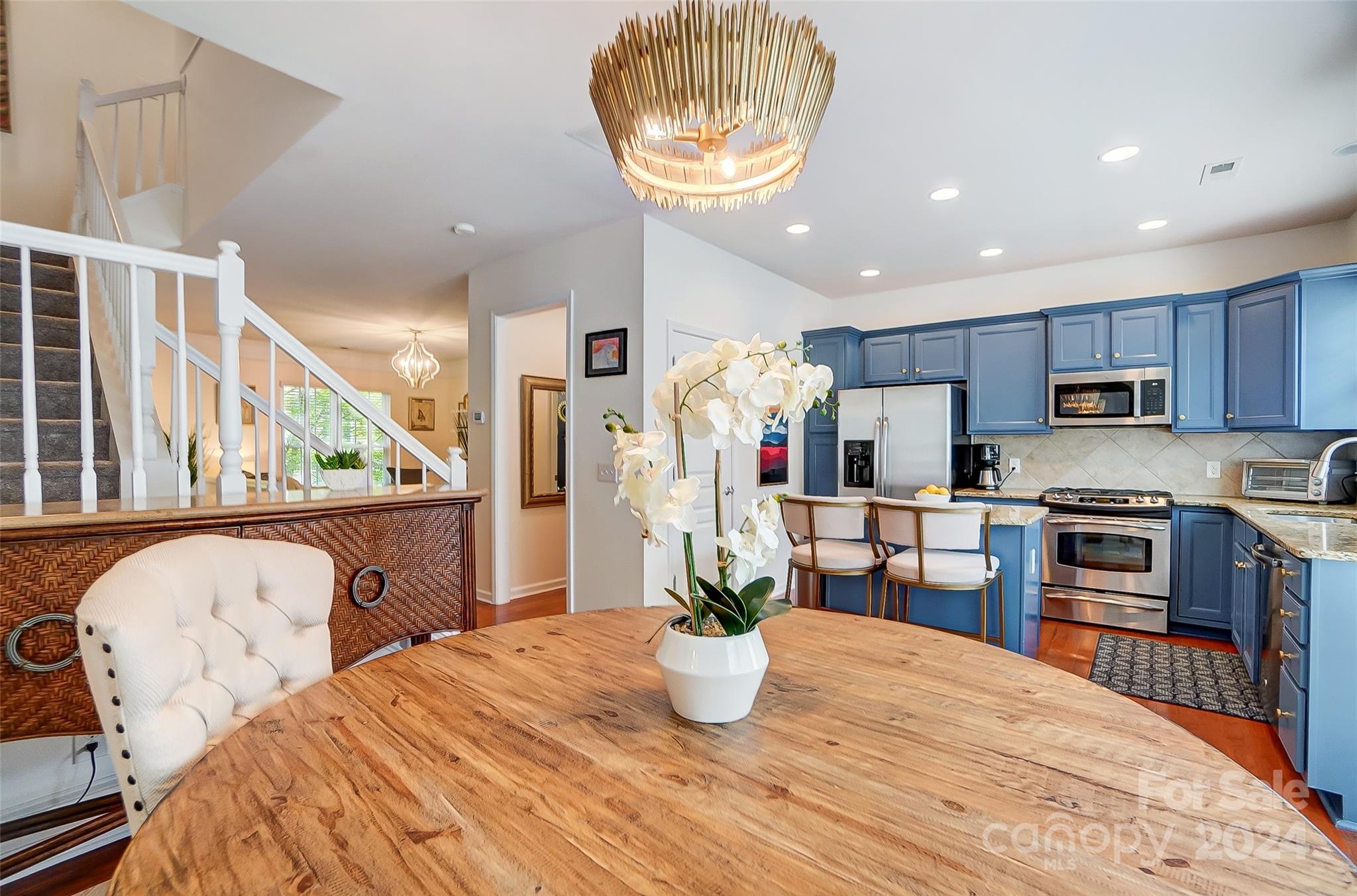 825 Granby Drive Fort Mill, SC 29708 - Photo 17 of 38 a kitchen with stainless steel appliances kitchen island granite countertop a refrigerator a stove top oven a sink dishwasher and chairs with wooden floor