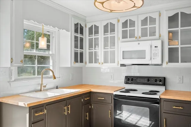 a kitchen with stainless steel appliances granite countertop a stove a sink and a microwave