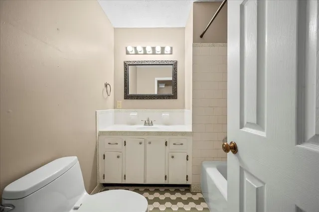 a bathroom with a toilet a sink and a mirror