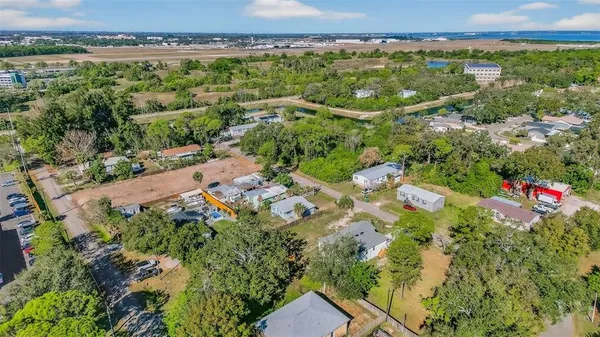 an aerial view of residential houses with outdoor space and trees
