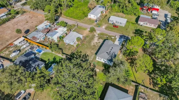 an aerial view of residential house with outdoor space and trees all around