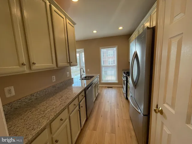 a view of a kitchen with a sink and refrigerator