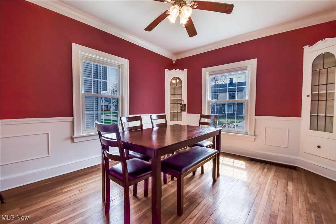 3733 East Antisdale Road Cleveland, OH 44118 - Photo 3 of 28 Dining space featuring ceiling fan, ornamental molding, wainscoting, and wood-type flooring