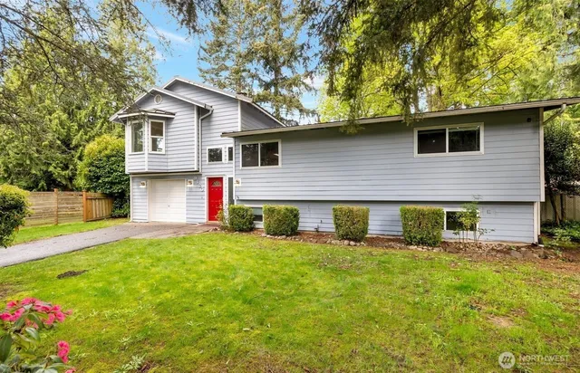 a front view of house with yard and trees in the background