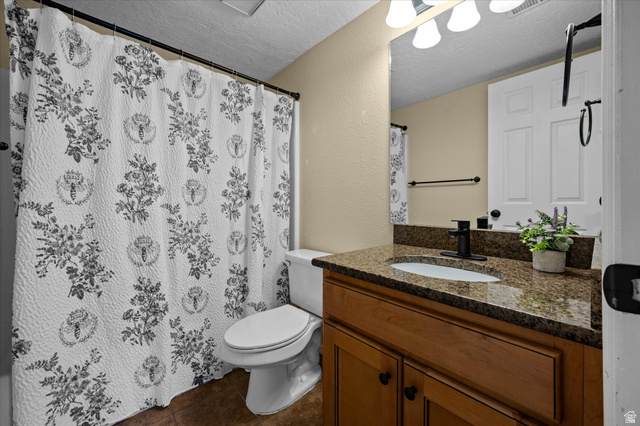 2095 South Main Street, Unit 13 Bountiful, UT 84010 - Photo 19 of 45 Full bath with a textured ceiling, vanity, a textured wall, curtained shower, and dark tile patterned flooring