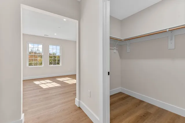 an empty room with wooden floor a exposed radiator and a window