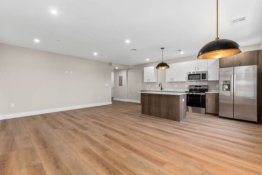 22 Everett Street, Unit 424 Westwood, MA 02090 - Photo 4 of 30 a kitchen with stainless steel appliances a refrigerator and a wooden floor