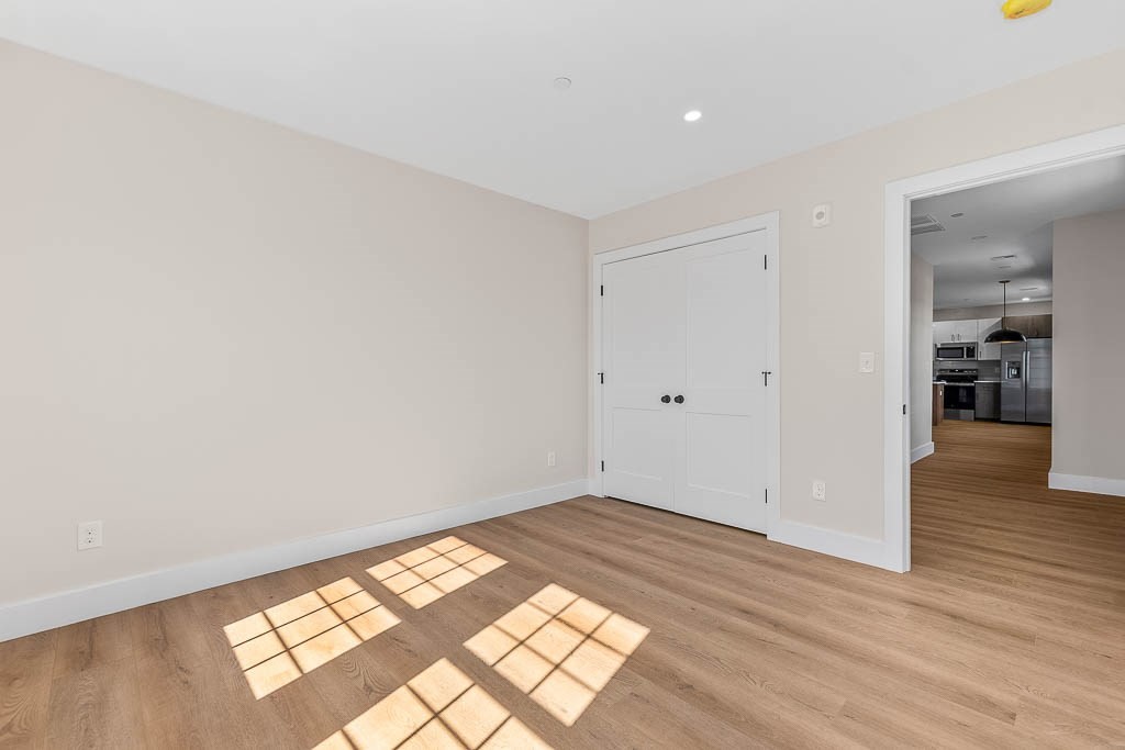 22 Everett Street, Unit 424 Westwood, MA 02090 - Photo 10 of 30 an empty room with wooden floor and windows