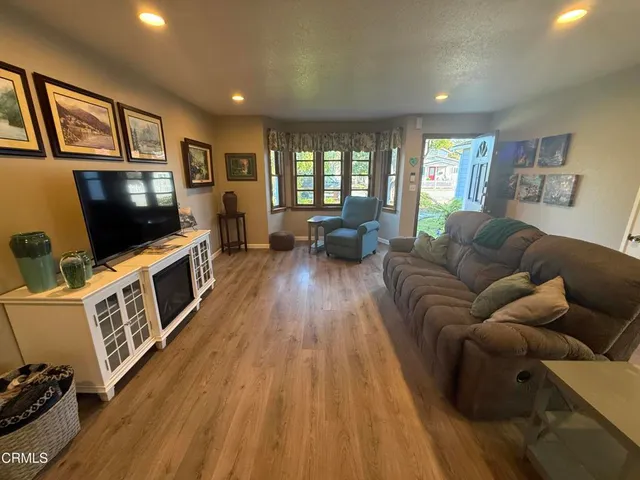 a view of a a dining room with furniture window and wooden floor