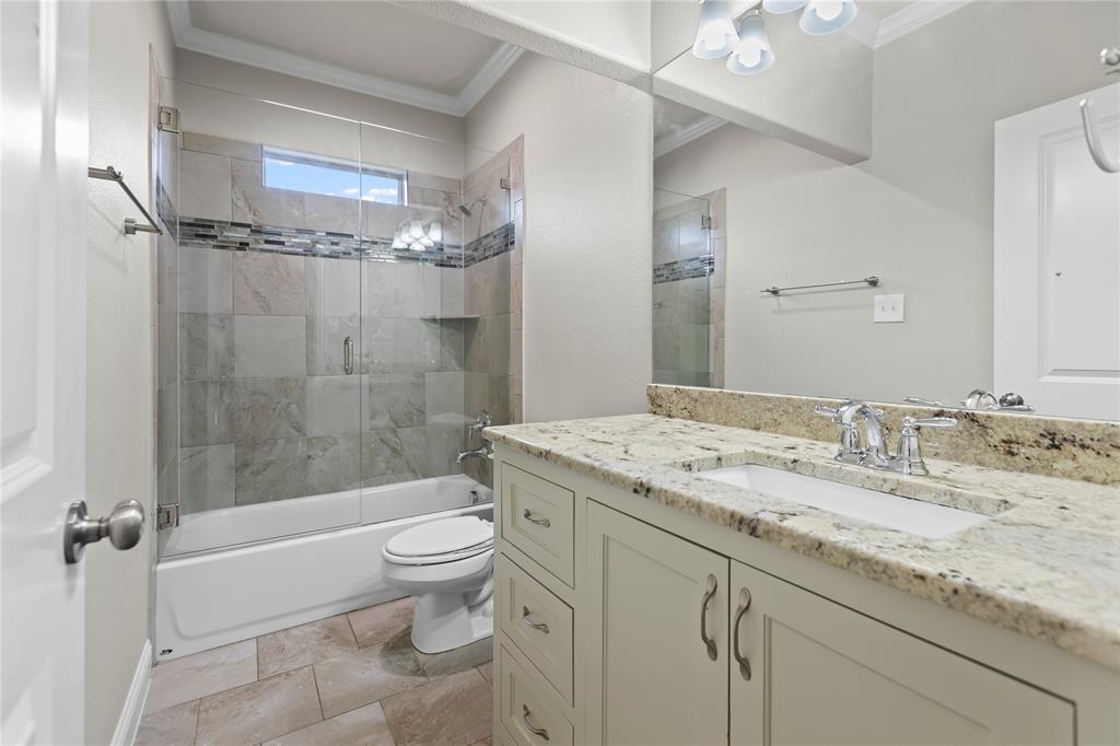 7806 Garner Road Rowlett, TX 75088 - Photo 22 of 34 a bathroom with a granite countertop sink a toilet and shower