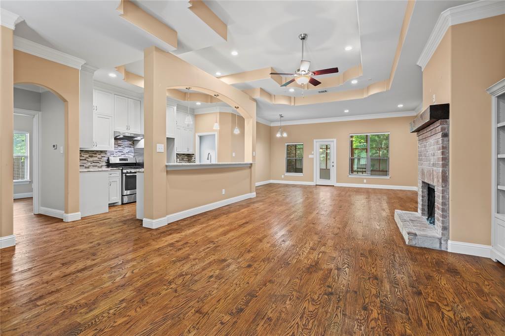 7806 Garner Road Rowlett, TX 75088 - Photo 7 of 34 an empty room with wooden floor kitchen view and a window