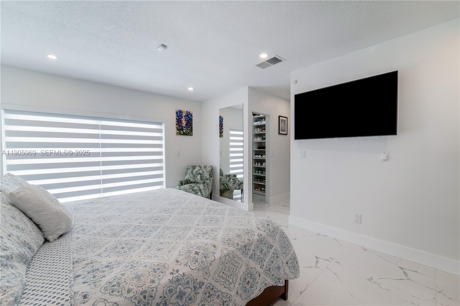 9746 Southwest 147th Court Miami, FL 33196 - Photo 24 of 42 a spacious bedroom with a bed and a flat screen tv