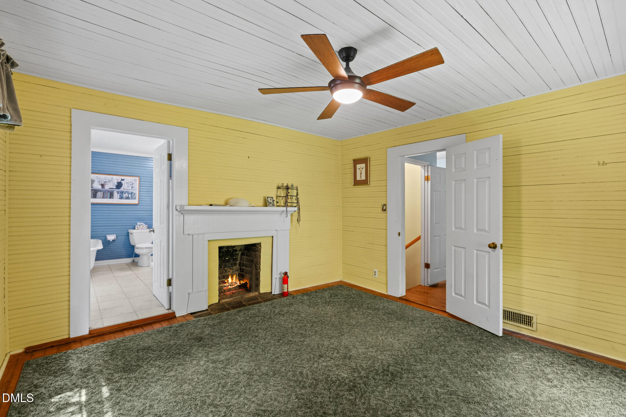 3415 Mt Willing Road Efland, NC 27243 - Photo 14 of 36 a living room with a fireplace and a ceiling fan