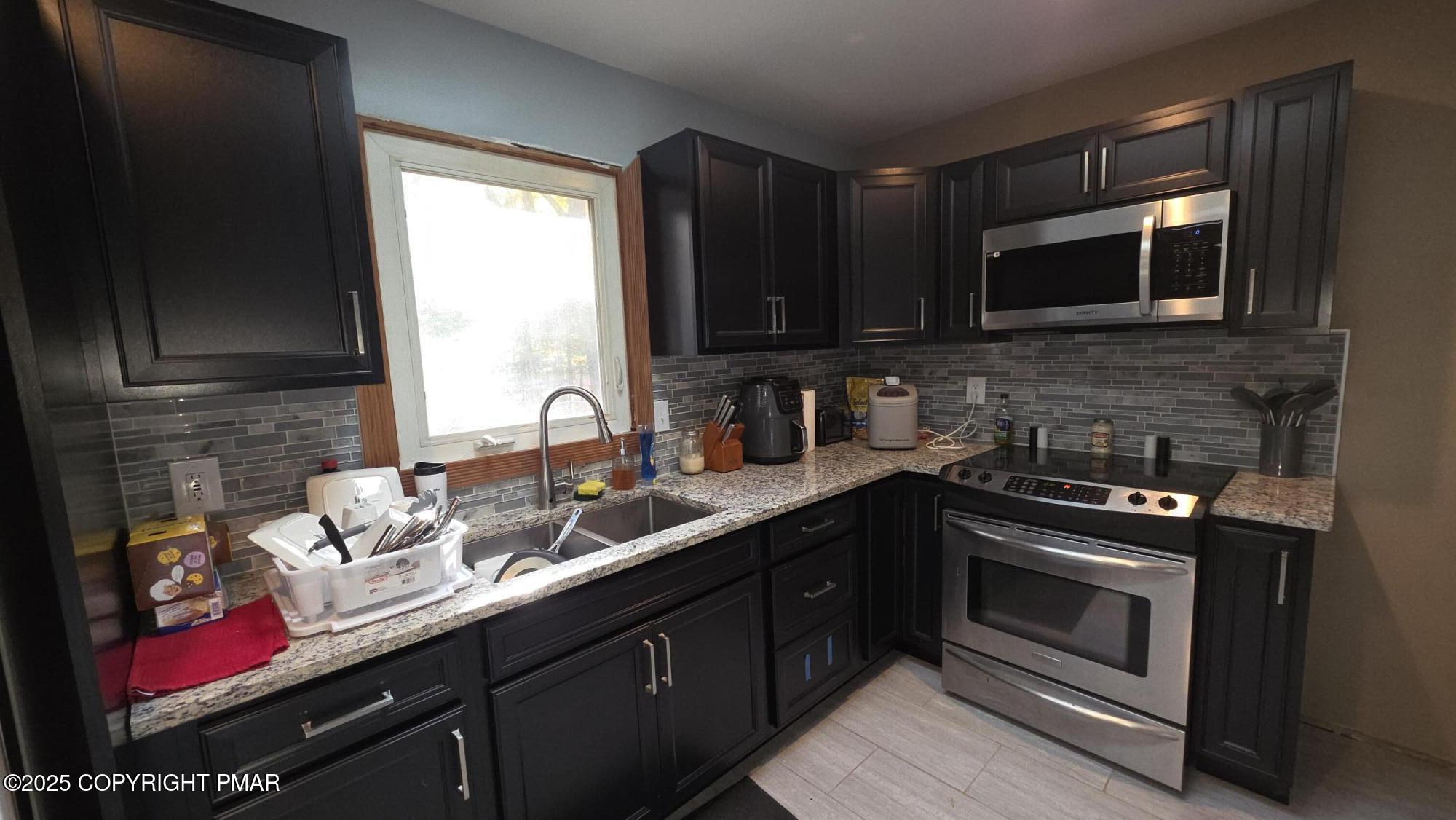 781 White Oak Road Cresco, PA 18326 - Photo 14 of 37 a kitchen with stainless steel appliances a stove sink microwave and cabinets