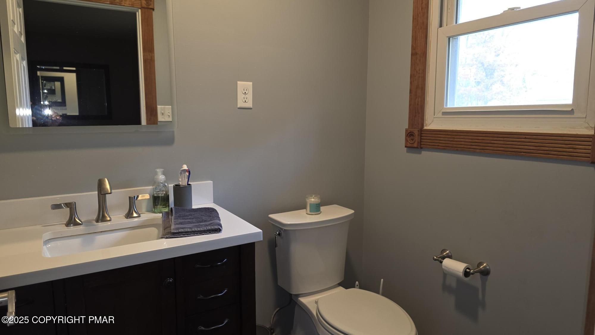 781 White Oak Road Cresco, PA 18326 - Photo 16 of 37 a bathroom with a toilet sink a mirror and window