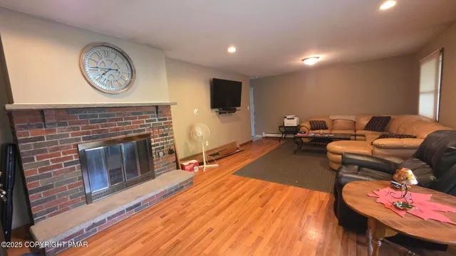 a living room with furniture a clock and a fireplace