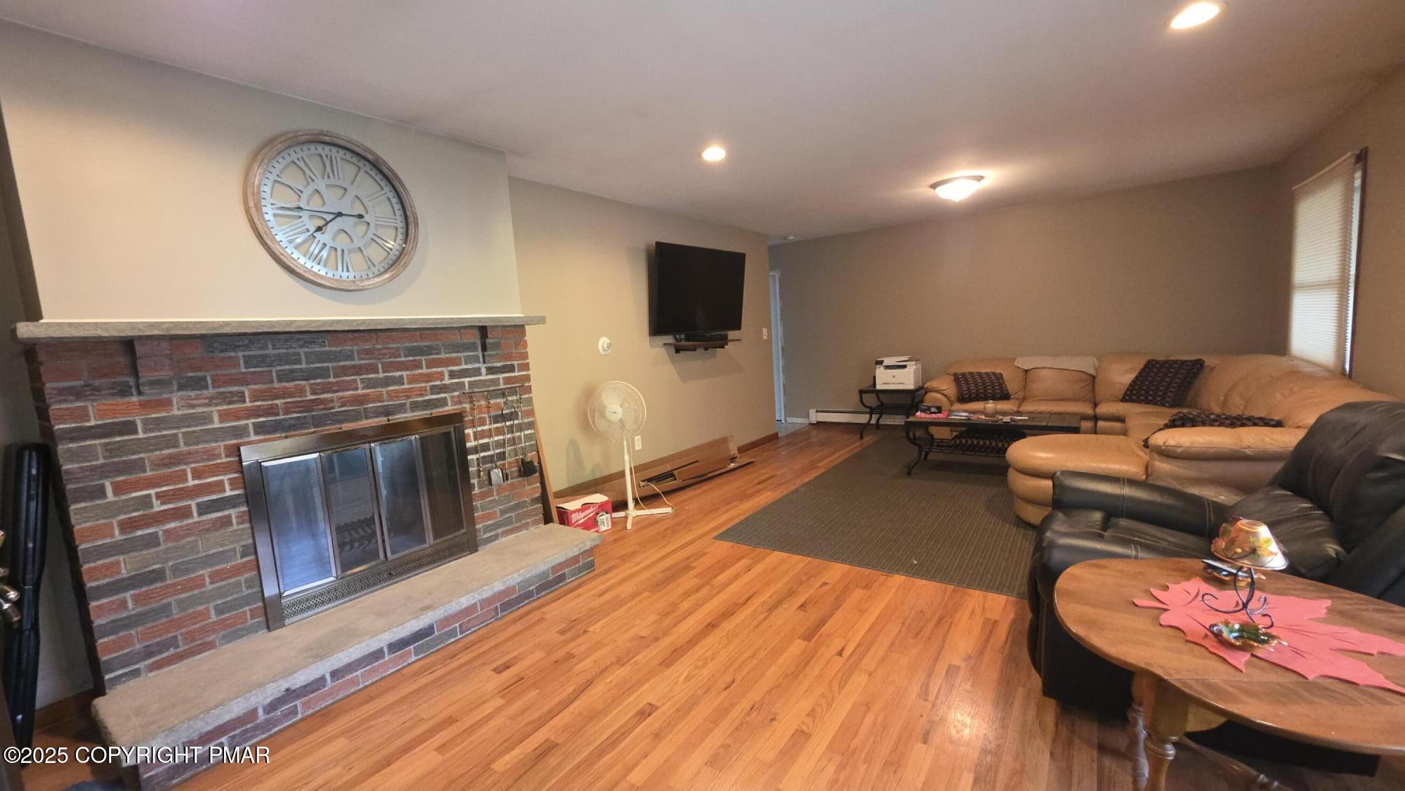 781 White Oak Road Cresco, PA 18326 - Photo 5 of 37 a living room with furniture a clock and a fireplace